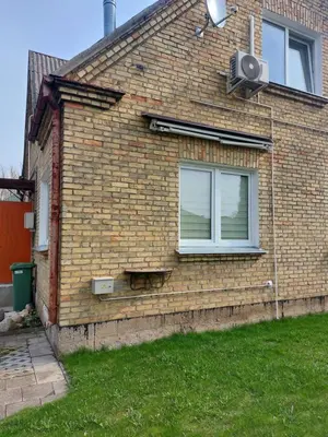 a brick house with a window on the side of it at Kotedžas nuomai - Retro 70, Šiauliai in Šiauliai