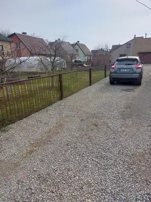 a car parked in a driveway next to a fence at Kotedžas nuomai - Retro 70, Šiauliai in Šiauliai