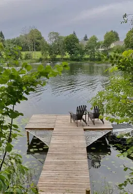 two chairs sitting on a wooden dock over a lake at Island House atostogų namai in Gaylyunay