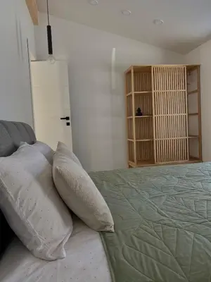 a bedroom with a bed with two pillows on it at Island House atostogų namai in Gaylyunay