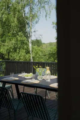 a table with chairs and a bowl of food on a deck at Island House atostogų namai in Gaylyunay