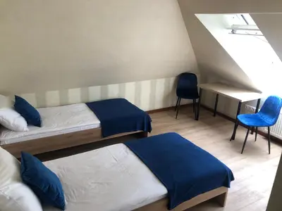 a room with two beds and a desk and a chair at Bed&Blues in Vilnius