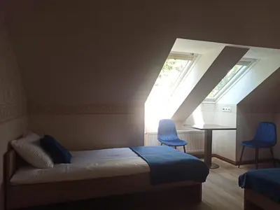 a bedroom with a bed and two blue chairs at Bed&Blues in Vilnius