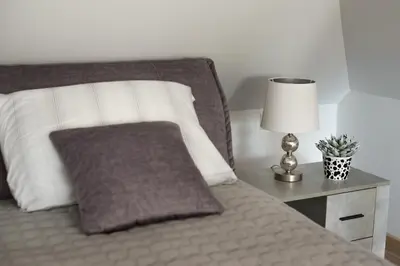 a bed with a pillow and a lamp on a night stand at Petro studija in Kaunas
