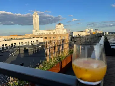 a glass of beer sitting on a balcony with a view at Center stay Kaunas - Peledyne - Owl's nest apartments in Kaunas