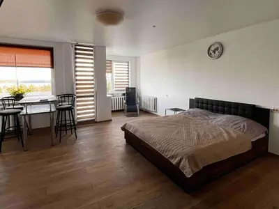 a bedroom with a bed and a table and chairs at Studio Apartment with Lake View in Visaginas