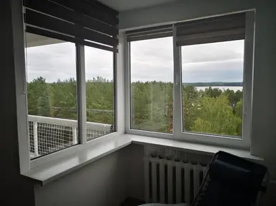 a room with three windows with a radiator and a view at Studio Apartment with Lake View in Visaginas