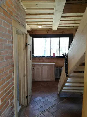an attic room with a staircase and a brick wall at Antalieptės sodyba in Baibiai