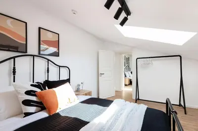 a bedroom with a black and white bed and a window at #stayhere - Modern & Central 2 Bedroom Apartment in Vilnius