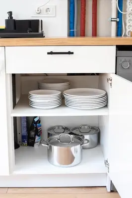 a kitchen cabinet with plates and dishes in it at #stayhere - Modern & Central 2 Bedroom Apartment in Vilnius