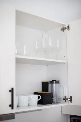 a kitchen cabinet with cups and utensils on it at #stayhere - Modern & Central 2 Bedroom Apartment in Vilnius