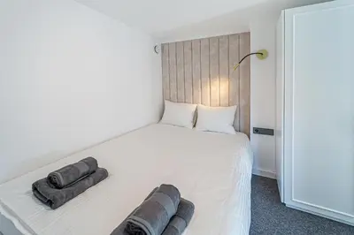 a bedroom with a white bed with two pillows on it at Ministerija Loft Apartment with parking & AC in Kaunas