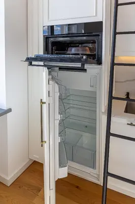 an empty refrigerator with its door open in a kitchen at Ministerija Loft Apartment with parking & AC in Kaunas
