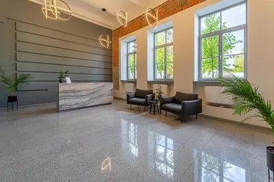 a waiting room with chairs and a table and windows at Ministerija Loft Apartment with parking & AC in Kaunas