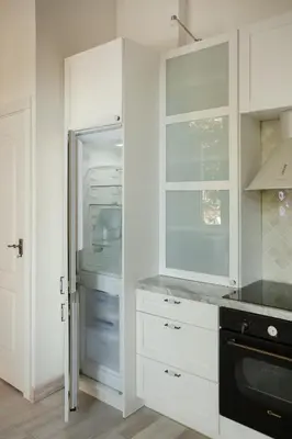 a kitchen with white cabinets and an open refrigerator at 20 stairs in Vilnius