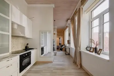 a kitchen with white cabinets and a large window at 20 stairs in Vilnius