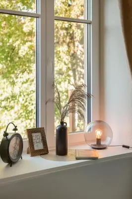 a window sill with a candle and a clock and a book at 20 stairs in Vilnius