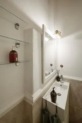 a white bathroom with a sink and a mirror at 20 stairs in Vilnius