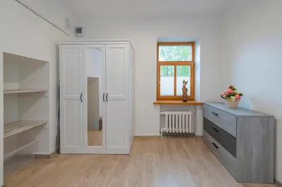 a room with a closet and a dresser and a window at Historical Oldtown Charm with Modern Comfort by Polo Apartments in Kaunas