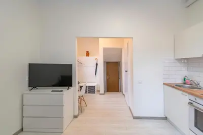 a kitchen with a flat screen tv on a white cabinet at Historical Oldtown Charm with Modern Comfort by Polo Apartments in Kaunas