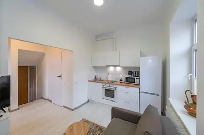 a kitchen with white cabinets and a white refrigerator at Historical Oldtown Charm with Modern Comfort by Polo Apartments in Kaunas