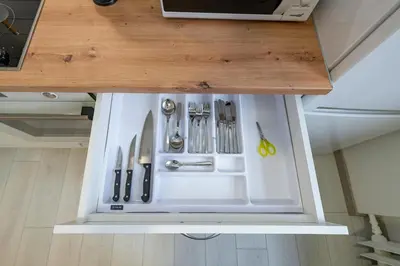 a white refrigerator with silver utensils in it at Historical Oldtown Charm with Modern Comfort by Polo Apartments in Kaunas