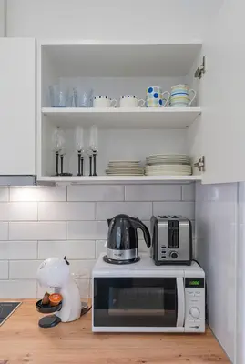 a kitchen with a microwave and a tea kettle on a counter at Historical Oldtown Charm with Modern Comfort by Polo Apartments in Kaunas