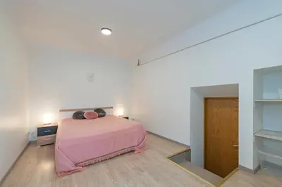 a bedroom with a pink bed in a white room at Historical Oldtown Charm with Modern Comfort by Polo Apartments in Kaunas