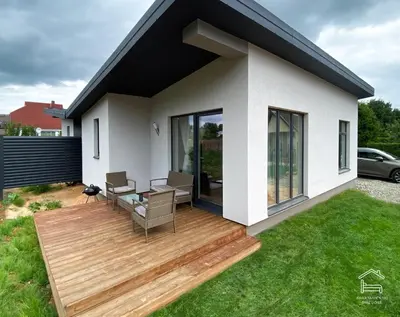 a house with a wooden deck in a yard at Apartamentai Biržuose, Cozy Modern Bungalows in Biržai