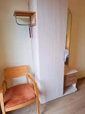 a chair and a mirror in a small room at LUNA Marijampole in Marijampolė