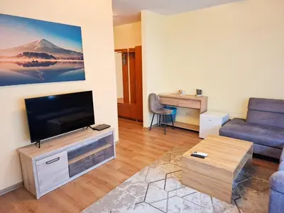 a living room with a tv and a couch at LUNA Marijampole in Marijampolė