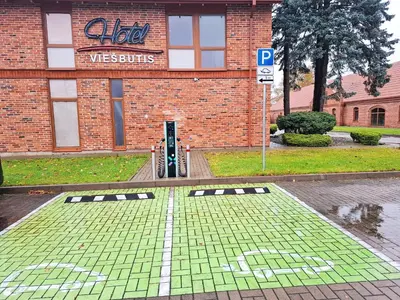 a brick building with a door and a parking sign at LUNA Marijampole in Marijampolė