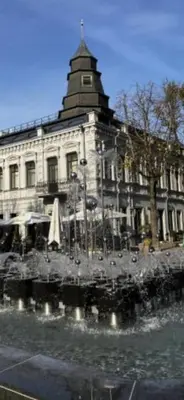 a large building with a fountain in front of it at Arena apartment in Kaunas