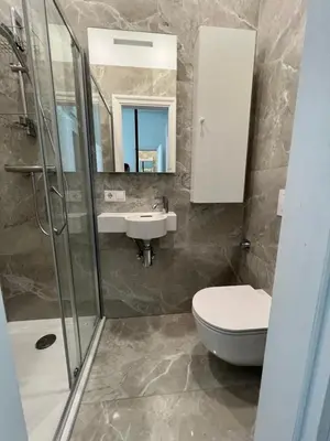 a bathroom with a sink and a toilet and a mirror at Arena apartment in Kaunas