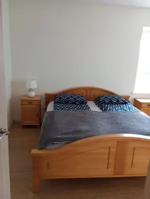 a bedroom with a wooden bed with blue pillows at Antonio house in Ramučiai