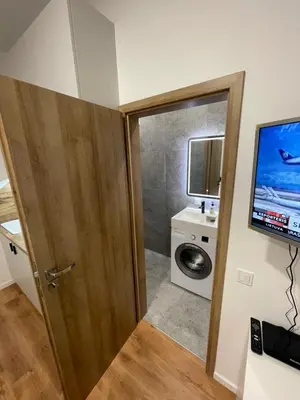 a bathroom with a door and a washing machine at 29 Airport Apartment in Vilnius