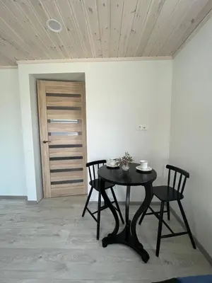 a black table and chairs in a room with a door at SKA Anykščiai in Anykščiai