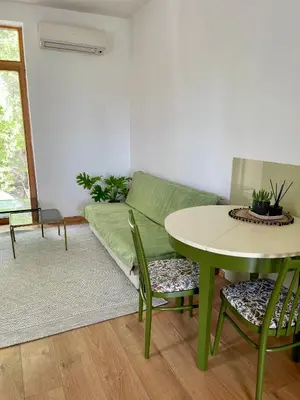 a living room with a green couch and a table at Kaunas Green in Kaunas
