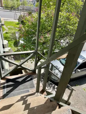 a porch with stairs and a car parked on the street at Kaunas Green in Kaunas
