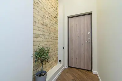 a hallway with a wooden door and a plant at FREE PARKING Old Town Central Station Apart with Balcony in Vilnius