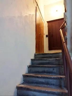 a set of stairs with a wooden door at FREE PARKING Old Town Central Station Apart with Balcony in Vilnius