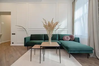 a living room with a green couch and a table at FREE PARKING Old Town Central Station Apart with Balcony in Vilnius