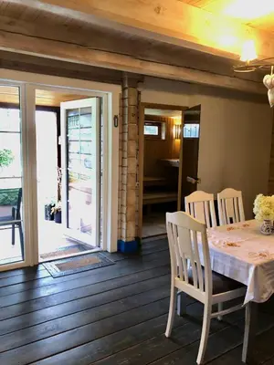a dining room with a table and chairs on a wooden floor at Sodyba Paukščių Takas in Aviliai