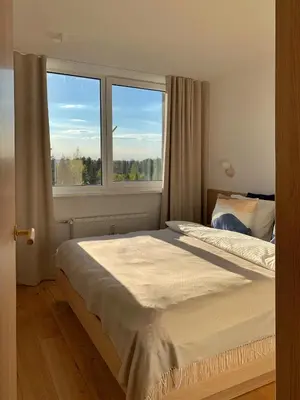 a bedroom with a bed and a large window at VANDUO Anykščiuose in Anykščiai
