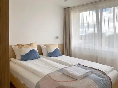 a bedroom with a large bed with a window at SMĖLIS Anykščiuose in Anykščiai