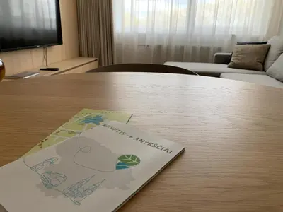 a sign on a table in a living room at SMĖLIS Anykščiuose in Anykščiai